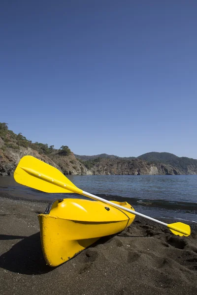 Kayak está en la playa contra el telón de fondo de las montañas . — Foto de Stock