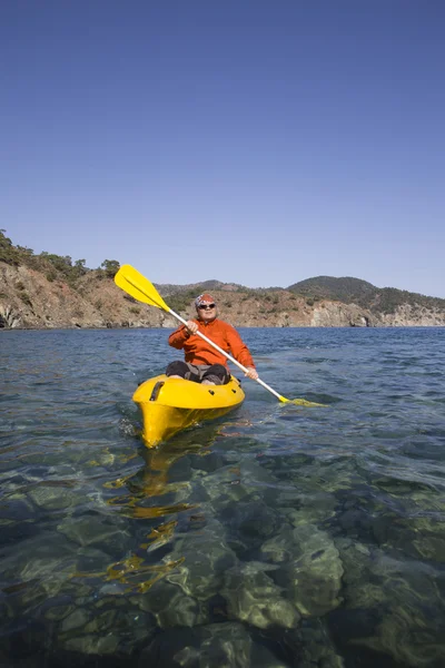 Un hombre que viaja en kayak de mar . — Foto de Stock