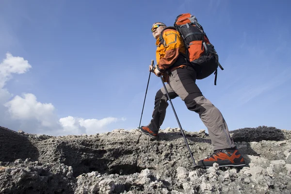 A traveler stands on top of a mountain and looks out to sea. — Stock Photo, Image