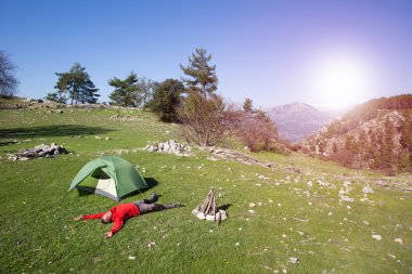 Bir gezgin bir dağın tepesinde duruyor ve denize bakıyor.