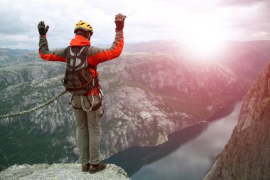 Young man jumping from a cliff into the abyss. clipart