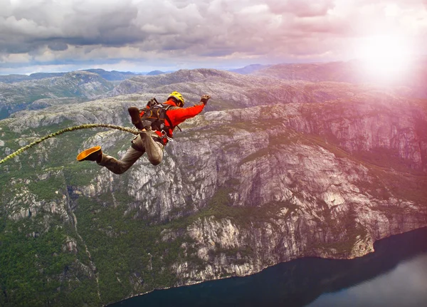 Ung man hoppa från en klippa i avgrunden. — Stockfoto