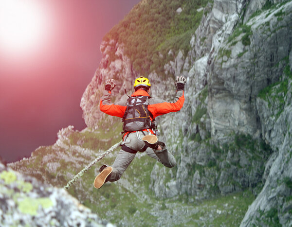 Молодой человек прыгает со скалы в пропасть
.