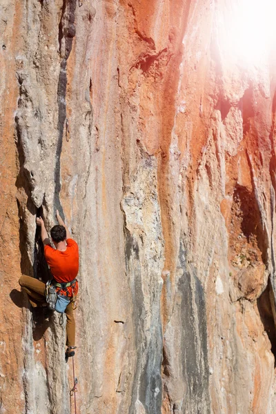 Athlète grimpe sur un rocher contre les montagnes . — Photo