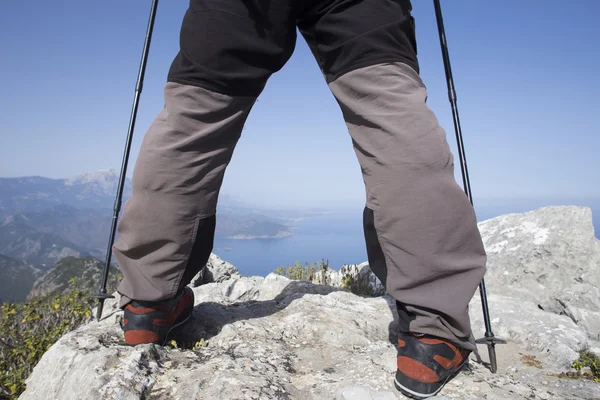 Un viaggiatore si trova sulla cima di una montagna e si affaccia sul mare . — Foto Stock