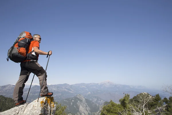 Un viaggiatore si trova sulla cima di una montagna e si affaccia sul mare . — Foto Stock