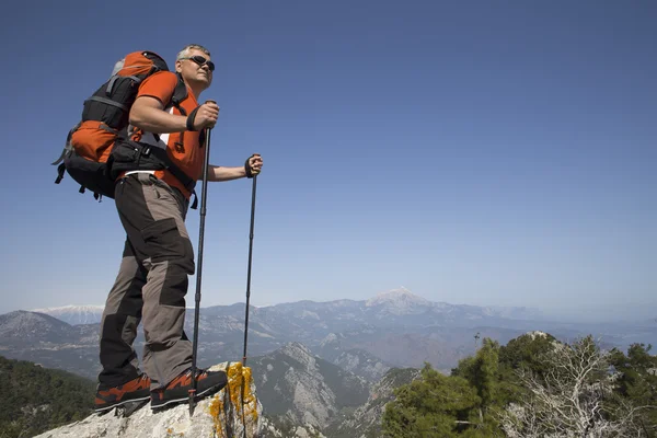 Un viaggiatore si trova sulla cima di una montagna e si affaccia sul mare . — Foto Stock