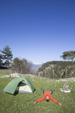Bir gezgin bir dağın tepesinde duruyor ve denize bakıyor.