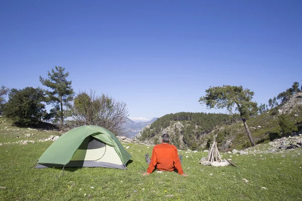 Un viaggiatore si trova sulla cima di una montagna e si affaccia sul mare . — Foto Stock