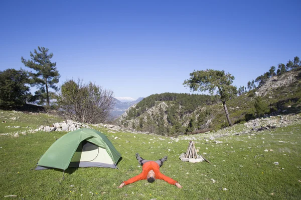 A traveler stands on top of a mountain and looks out to sea.