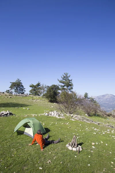 Bir gezgin bir dağın tepesinde duruyor ve denize bakıyor.