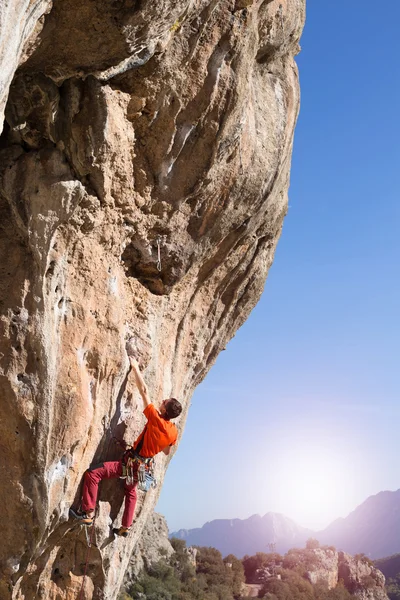 Junger männlicher Kletterer hängt an einer Klippe. — Stockfoto