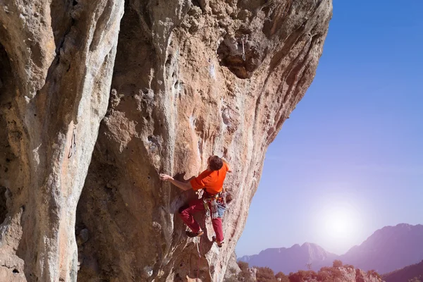 Uçurumun kenarında asılı genç bir tırmanıcı.