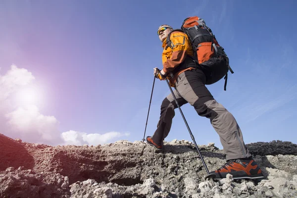 Un viajero se para en la cima de una montaña y mira hacia el mar . — Foto de Stock