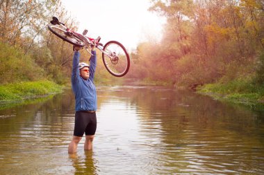 crossing kayalık arazi onun elinde bisiklet ile genç atlet.