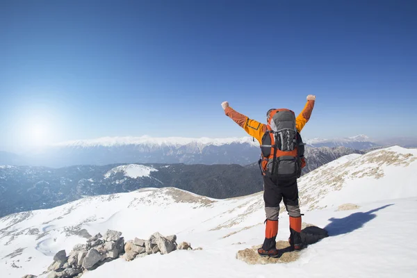 Un viajero se para en la cima de una montaña y observa el amanecer . — Foto de Stock