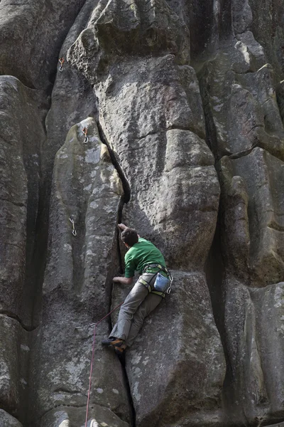 Νεαρός άνδρας ανεβαίνει σε ένα βράχο με ένα σχοινί. — Φωτογραφία Αρχείου