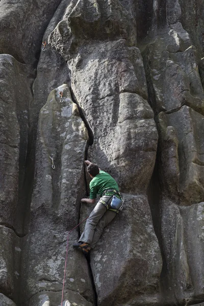 Young man climbs on a cliff with a rope. — Stock Photo, Image