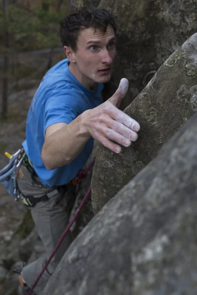 Молодий чоловік піднімається на скелі з мотузкою . — стокове фото