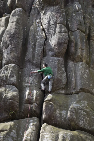 Giovane uomo sale su una scogliera con una corda . — Foto Stock