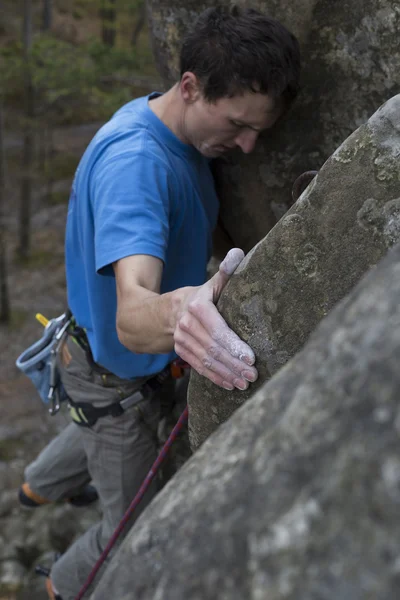 Unge mann klatrer på en klippe med tau . – stockfoto