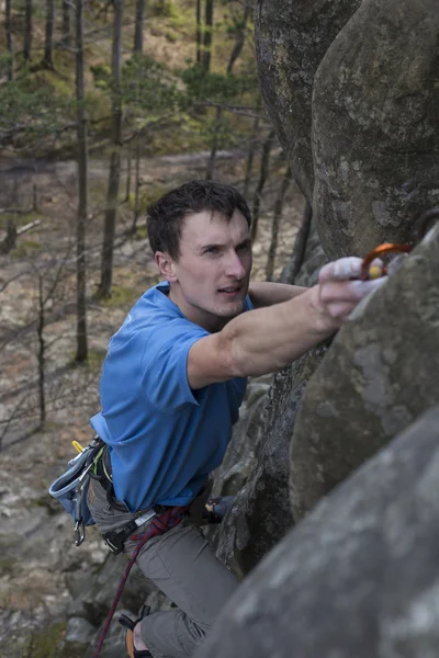 Junger Mann klettert mit Seil auf Klippe. — Stockfoto