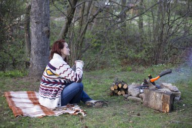 Bir kamp ateşi kamp alanında haritaya bakıyordum ve kahve içme yakın oturan kız.