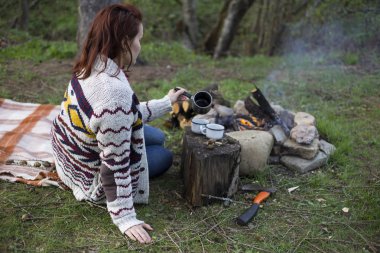 Bir kamp ateşi kamp alanında haritaya bakıyordum ve kahve içme yakın oturan kız.