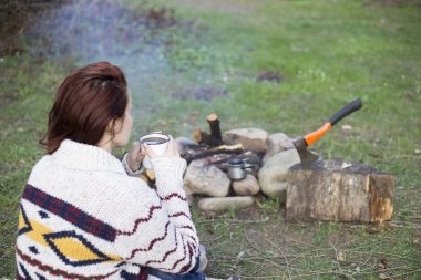 Bir kamp ateşi kamp alanında haritaya bakıyordum ve kahve içme yakın oturan kız.
