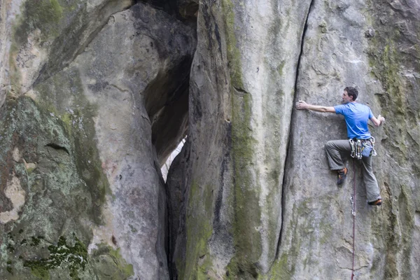 Athlete climbs on rock with rope. — Stock Photo, Image