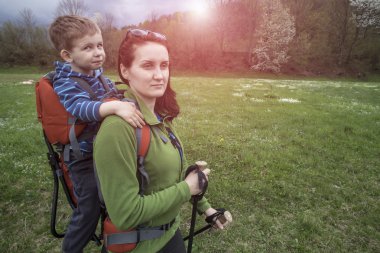 Anne çocuk taşımak içinde bir çocuk ile ormanda yürür.