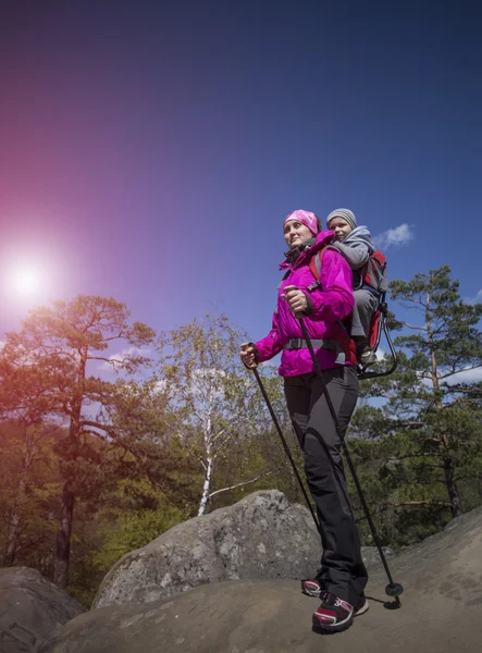 Mutter geht mit Kind im Wald spazieren, ein Kind in der Kindertrage. — Stockfoto