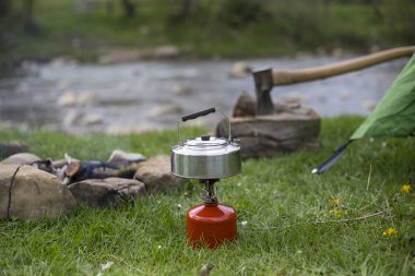 Kupa bir günlük bir kamp ateşi yanında duruyor.
