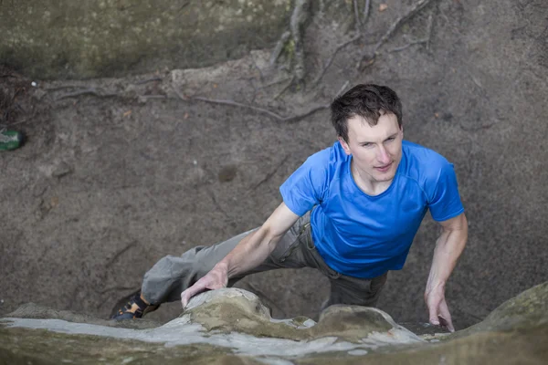 Αθλητής σκαρφαλώνει πάνω σε βράχο με σχοινί. — Φωτογραφία Αρχείου