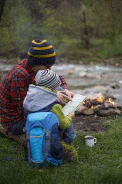 Baba ve oğul oturan bir kamp ateşi kamp alanında yakın ve l vardır