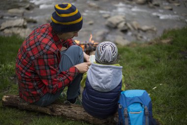 Baba ve oğul oturan bir kamp ateşi kamp alanında yakın ve l vardır