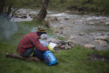 Baba ve oğul oturan bir kamp ateşi kamp alanında yakın ve l vardır
