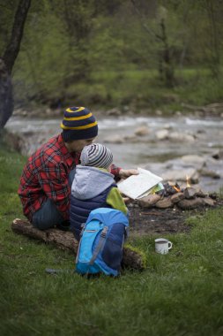 Baba ve oğul oturan bir kamp ateşi kamp alanında yakın ve l vardır