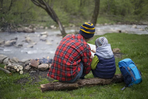 Baba ve oğul oturan bir kamp ateşi kamp alanında yakın ve l vardır