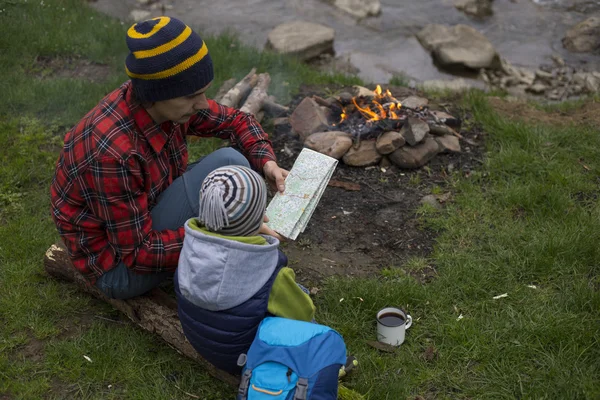 Baba ve oğul oturan bir kamp ateşi kamp alanında yakın ve l vardır