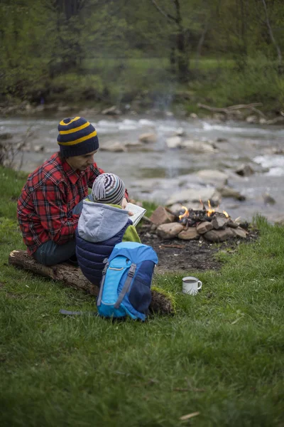 Baba ve oğul oturan bir kamp ateşi kamp alanında yakın ve l vardır