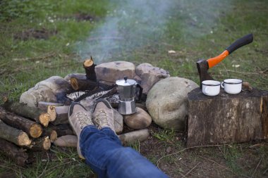 Bir kız tarafından yangın ve içecek kahve oturuyor.