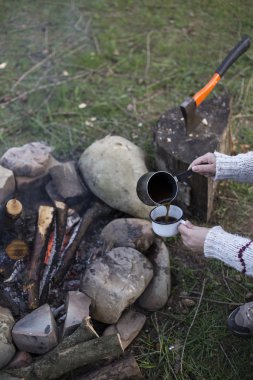 Bir kız tarafından yangın ve içecek kahve oturuyor.