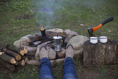 Bir kız tarafından yangın ve içecek kahve oturuyor.