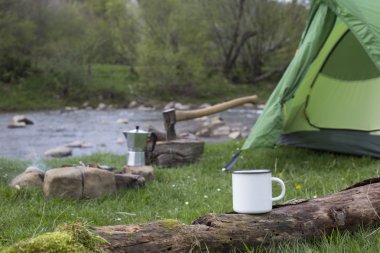 Kupa bir günlük bir kamp ateşi yanında duruyor.
