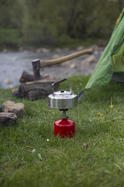 Kupa bir günlük bir kamp ateşi yanında duruyor.