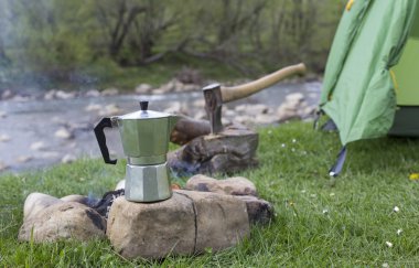 Kupa bir günlük bir kamp ateşi yanında duruyor.