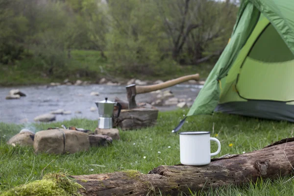Kupa bir günlük bir kamp ateşi yanında duruyor.