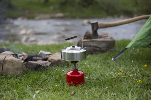 Kupa bir günlük bir kamp ateşi yanında duruyor.