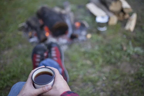 Hombre bebiendo café junto al fuego . — Foto de Stock